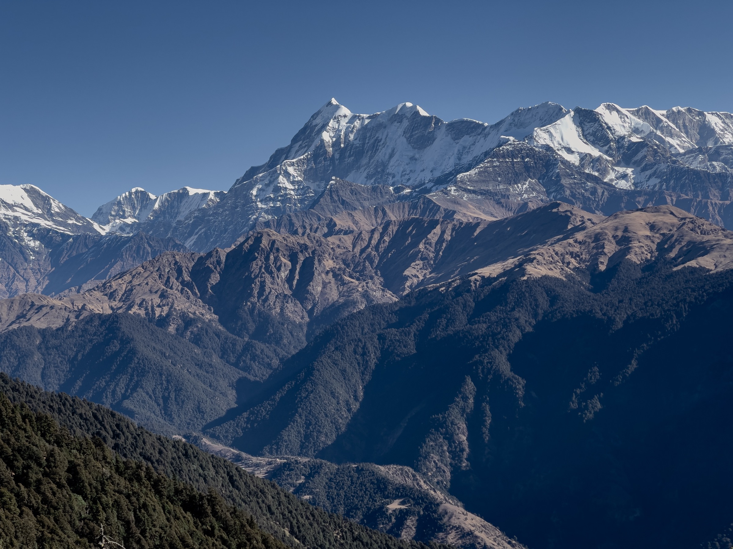 Snow-covered mountain range under a clear blue sky